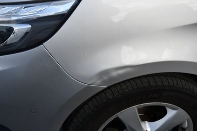 un gros plan du pare-chocs avant d'une voiture présentant une bosse