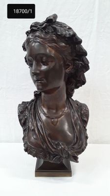 une image représentant un buste de femme en bronze posé sur un socle en bois