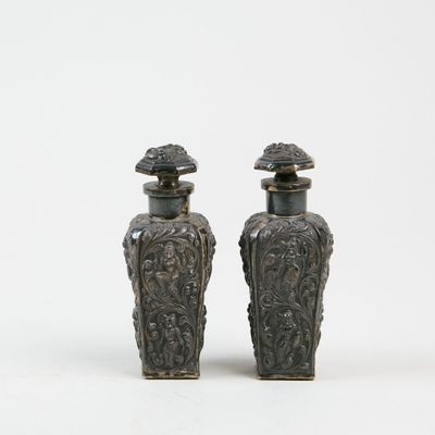 une paire de vases en argent posés sur une surface blanche, sur fond blanc