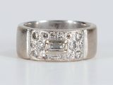 a close up of a diamond ring on a white surface