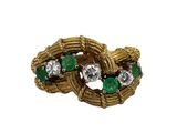 a close up of a gold ring with green and white stones