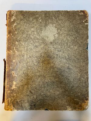 un vieux livre posé sur une table blanche à côté d'une tasse de café