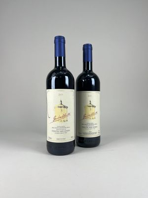 two bottles of wine sitting next to each other on a table