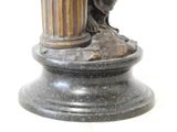 a statue of a bird sitting on top of a pillar