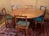une table en bois avec quatre chaises et un tapis au sol