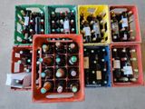 de nombreuses bouteilles de bière dans des récipients en plastique, par terre