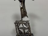 a statue of a man standing on top of a metal structure