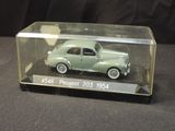 a small green car in a glass case