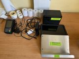 several rolls of toilet paper are sitting on a table next to a printer and a cell phone