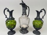 trois vases en verre vert posés les uns à côté des autres sur une table