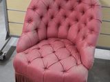 une chaise rose ornée de franges dans une pièce