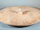 une petite assiette en bois sur laquelle est posé un coquillage