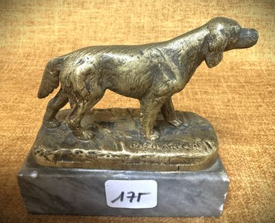 statue en bronze représentant un chien, posée sur un socle en marbre sur lequel est fixée une étiquette