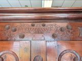 a large wooden bed with carvings on the top of it