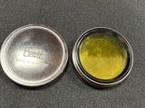 a small tin with a yellow substance inside of it