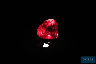 un diamant rouge en forme de cœur sur un fond noir