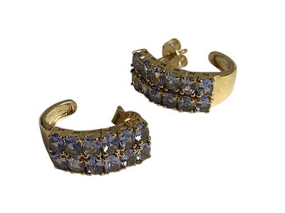 une paire de boucles d'oreilles dorées ornées de cristaux bleus