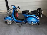 a blue scooter parked in front of a garage door