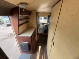 an image of a narrow room with a refrigerator and shelves