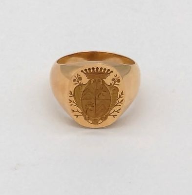 un gros plan d'une bague en or ornée d'un blason