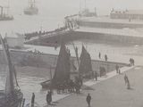 a black and white photo of a harbor with boats and people