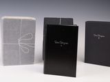 trois livres en noir et blanc sont alignés sur une surface blanche