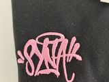 a close up of a black shirt with a pink logo on it