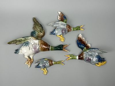 quatre canards volent en cercle sur une surface grise
