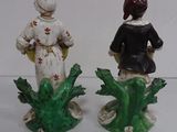 two figurines of a woman and a man standing next to each other