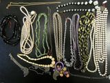 several necklaces and bracelets are arranged on a black surface