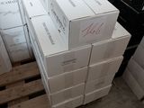 Plusieurs cartons de vin sont empilés sur des palettes dans un entrepôt