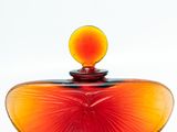 a red and orange glass heart shaped box with a yellow top