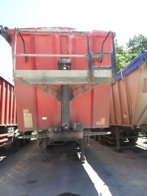 un camion-benne rouge garé à côté d'un autre camion-benne rouge