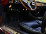 the interior of a red sports car with its door open