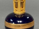a blue and gold vase with a cage on top
