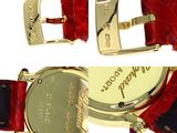 a close up of a wrist watch with a red strap