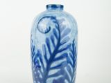 a blue and white vase sitting on a white surface