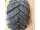 two large tires sitting on the side of a building next to a wall