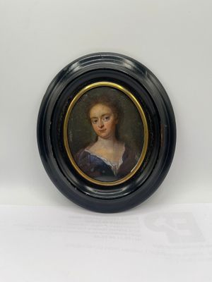 portrait of a woman in a blue dress in a black oval frame