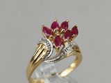 a close up of a gold ring with ruby and diamonds
