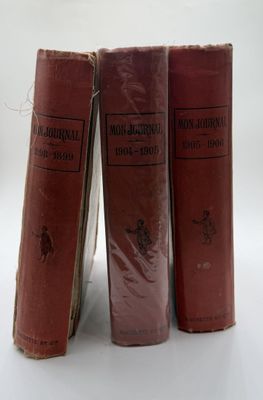 three red books sitting on top of each other on a white surface