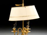 an antique brass table lamp with a white shade on a black background