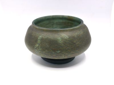a close up of a small green bowl on a white surface