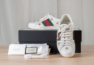 GUCCI Paire de baskets basses en cuir blanc rebrodé d'étoile…