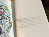 someone is holding a book with a drawing of a bus on it