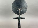 une image représentant une sculpture d'une femme tenant un grand disque