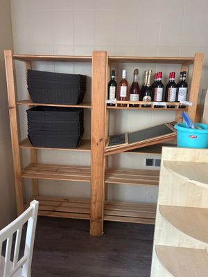 a shelf with bottles of wine on it in a kitchen