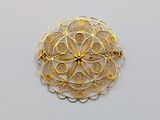 an image of a gold broochle on a white surface