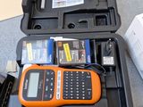 un téléphone portable orange et noir dans un étui, posé sur une table