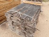 several pieces of wood are stacked on top of each other in front of a building